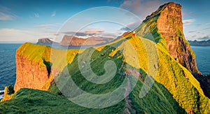 Landscape photography. Tourist walks on the trek to Kallur Lighthouse, Kalsoy island.