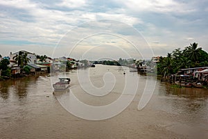 A landscape pictures of the shores of the mekong river in south vietnam near vinh long on a sunny summer day