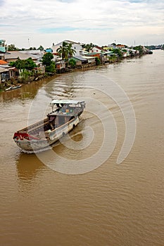 A landscape pictures of the shores of the mekong river in south vietnam near vinh long on a sunny summer day