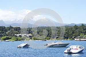 Landscape of Pucon volcano erupting and lake Villarrica and Marina with yachts