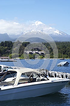 Landscape of Pucon volcano erupting and lake Villarrica and Marina with yachts