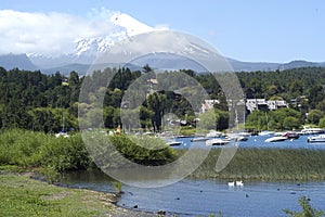 Landscape of Pucon volcano erupting and lake Villarrica and Marina with yachts