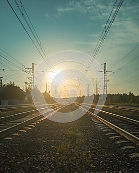 Landscape with railway tracks and a red signal of a semaphore in the rays of the setting sun