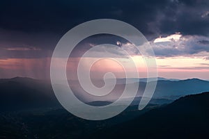 Landscape of rain clouds over the valley between mountains