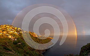 Landscape with rainbow over Canico at sunset time in Madeira