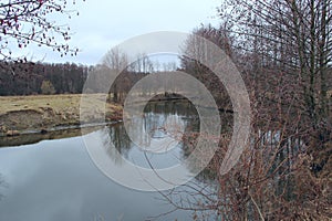 Landscape with river in autumn. Trees are reflected in water of river