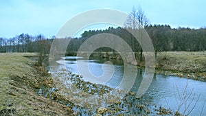 Landscape with river in autumn. Trees are reflected in water of river