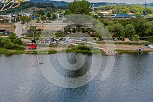 Landscape of river and camping site under cloudy sky