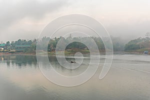 Landscape of river and houseboat with morning mist