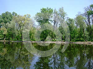 Landscape on the river with reflection of trees in the water