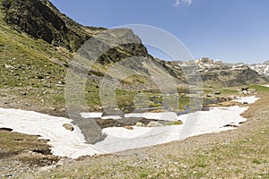 Landscape with a river and snowfields in the Ordina Arcalis area in Andorra