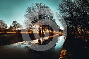 Landscape with river and trees at sunset. Toned image.