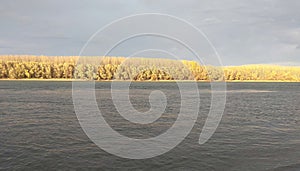 Landscape with river, yellow autumn shore and gray-blue sky