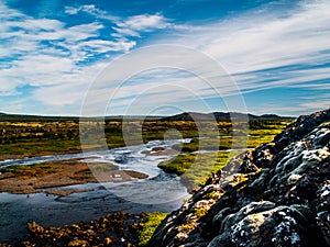 Landscape with Rivers, blue sky with clouds, green plants and hills in Iceland