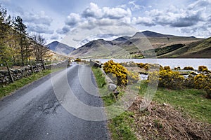 Landscape of road alongside Wast Water in Lake District in England with mountains in distance