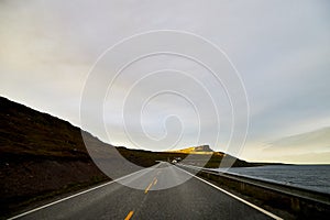 Landscape with road in tundra in Norway at cloudy evening