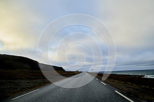 Landscape with road in tundra in Norway at cloudy evening