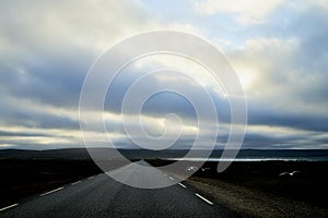 Landscape with road in tundra in Norway at cloudy evening