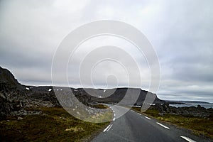 Landscape with road in tundra in Norway at cloudy evening