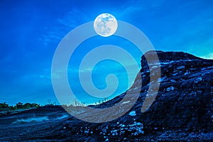 Landscape of the rock against blue sky and full moon above wilde