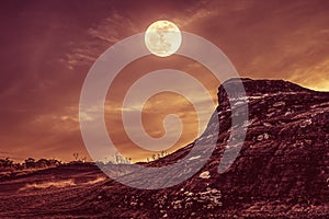 Landscape of rock with sky and full moon above wilderness area i