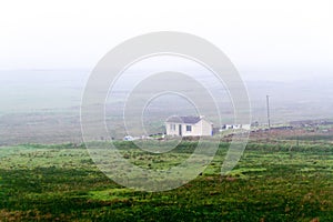 Landscape with a rural house in Doolin on a foggy day, Ireland