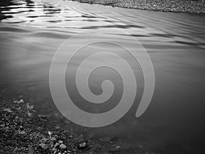 Landscape with rushing fast water stream with abstract pattern on surface, water flow motion in river