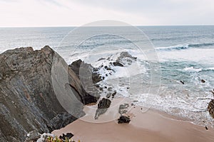 Landscape of the sandy Praia da Carraca beach with steep cliffs near the town of Cavaleiro in the Odemira region, western Portugal