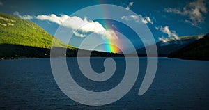 Landscape scene of Double Rainbow Over Kootenay Lake in Canada with cloudy sky