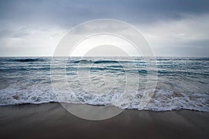 Landscape of a sea from the beach under a cloudy sky with a blurry background