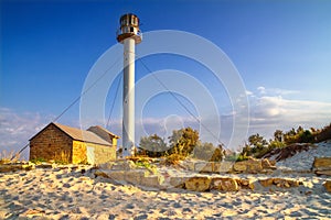 Landscape with sea lighthouse on the coast during sunrise