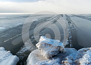 Landscape by the sea, snowy pieces of ice by the sea and ice texture at sea, dunes covered with a layer of white snow