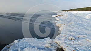 Landscape by the sea, snowy pieces of ice by the sea and ice texture at sea, dunes covered with a layer of white snow