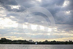 Landscape seascape view of cloudy sky and one lonely boat yach floating in calm river