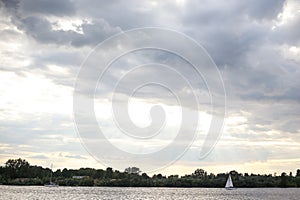 Landscape seascape view of cloudy sky and one lonely boat yach floating in calm river