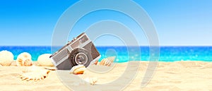 Landscape with seashells and old camera on tropical beach