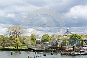 Landscape with several dutch houses and river under the cloudy sky