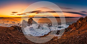 Landscape of Shamanka rock at sunset with natural breaking ice in frozen water on Lake Baikal, Siberia, Russia