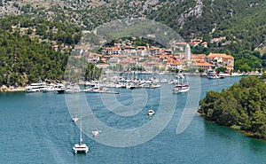 Landscape of ships and boats on a river surrounded by the Old Town of Skradin, Croatia