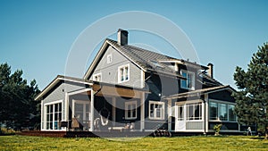 Landscape Shot with a Big Gray Residential Home on a Scenic Day with Clean Blue Sky. House in a S