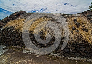 Landscape shot of golden-brown hays placed at the top of bedrock with a cloudy sky