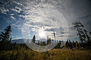 Landscape shot of the morning sun in the cloudy sky at Wapiti campground in Jasper National Park