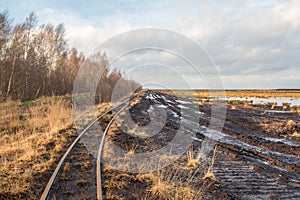 Landscape shot of a peat mining area with rails of a field railway