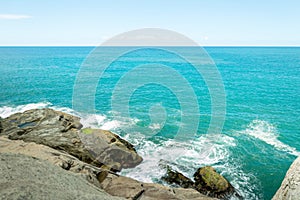 Landscape shot of sea and sky near a rocky corner.