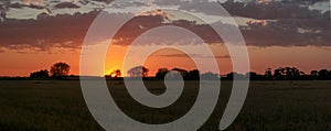 landscape showing the fiery burning colors of the sun setting in the clouds after a hot summers day in Australia