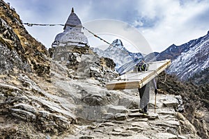 Landscape showing sherpa carrying heavy wooden doors hiking up the himalayan mountains towards the everest base camp, Nepal