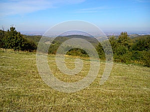 Landscape of slope Fruska mountains in Serbia in early autumn. Steep slope after haymaking. Dry grass is trimmed. In the