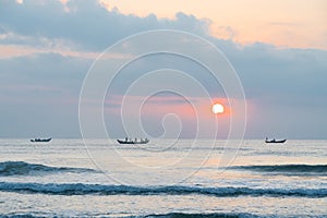 Landscape of small fishing boats of Vietnamese fishermen fishing at dawn in the sea