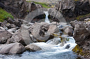 Landscape with small waterfall, river with clear water and rocks, Iceland