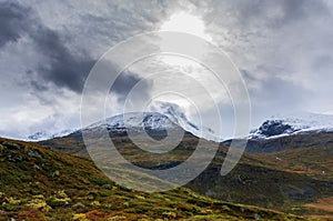 Landscape of snowy mountains and cloudy sky in Norway in summer